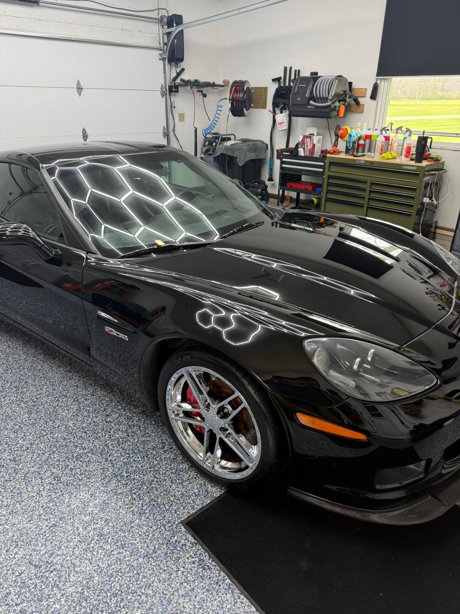 Black Corvette Z06 under hexagon garage lighting