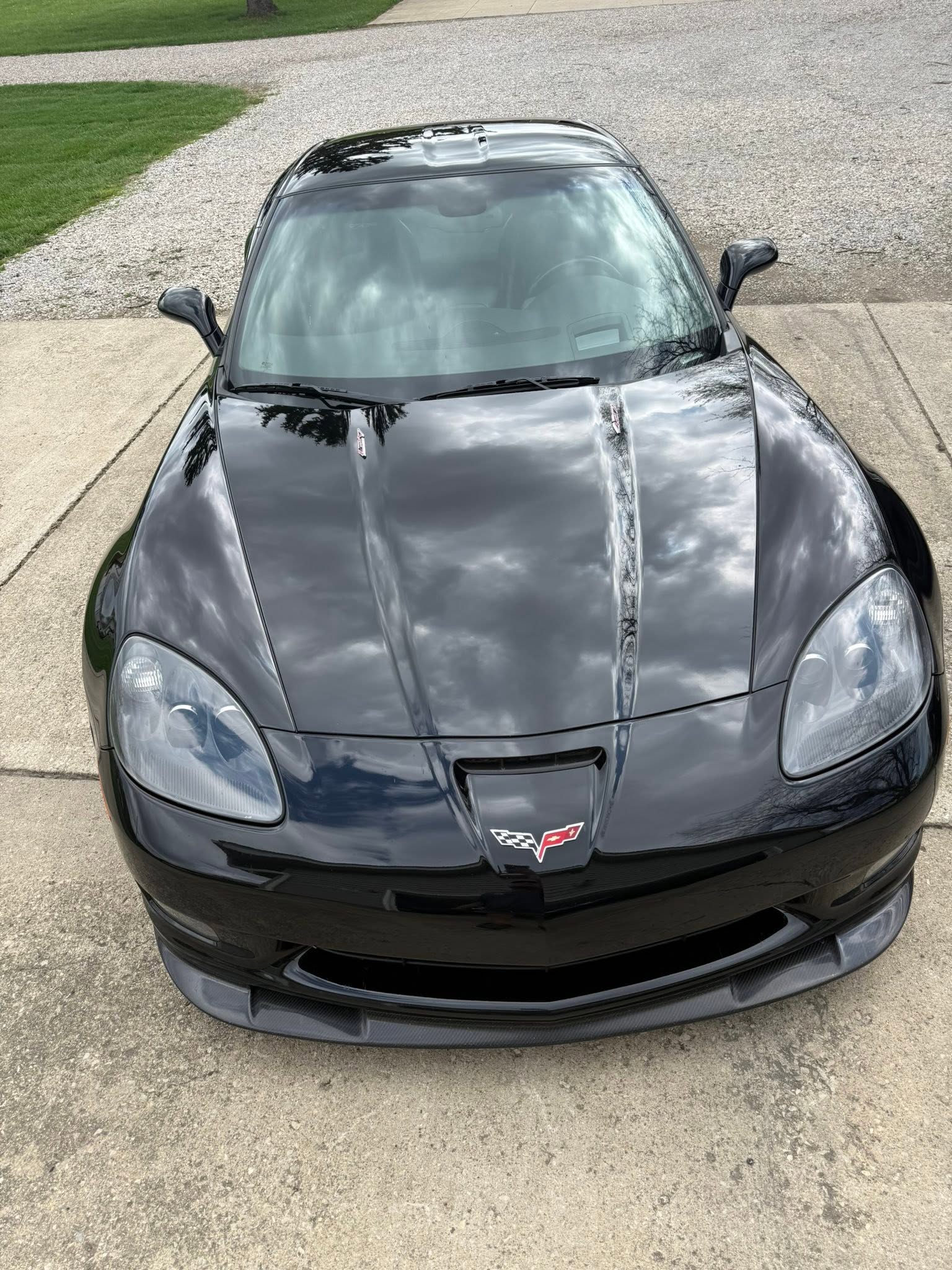 Clouds reflected in the hood of a black Corvette